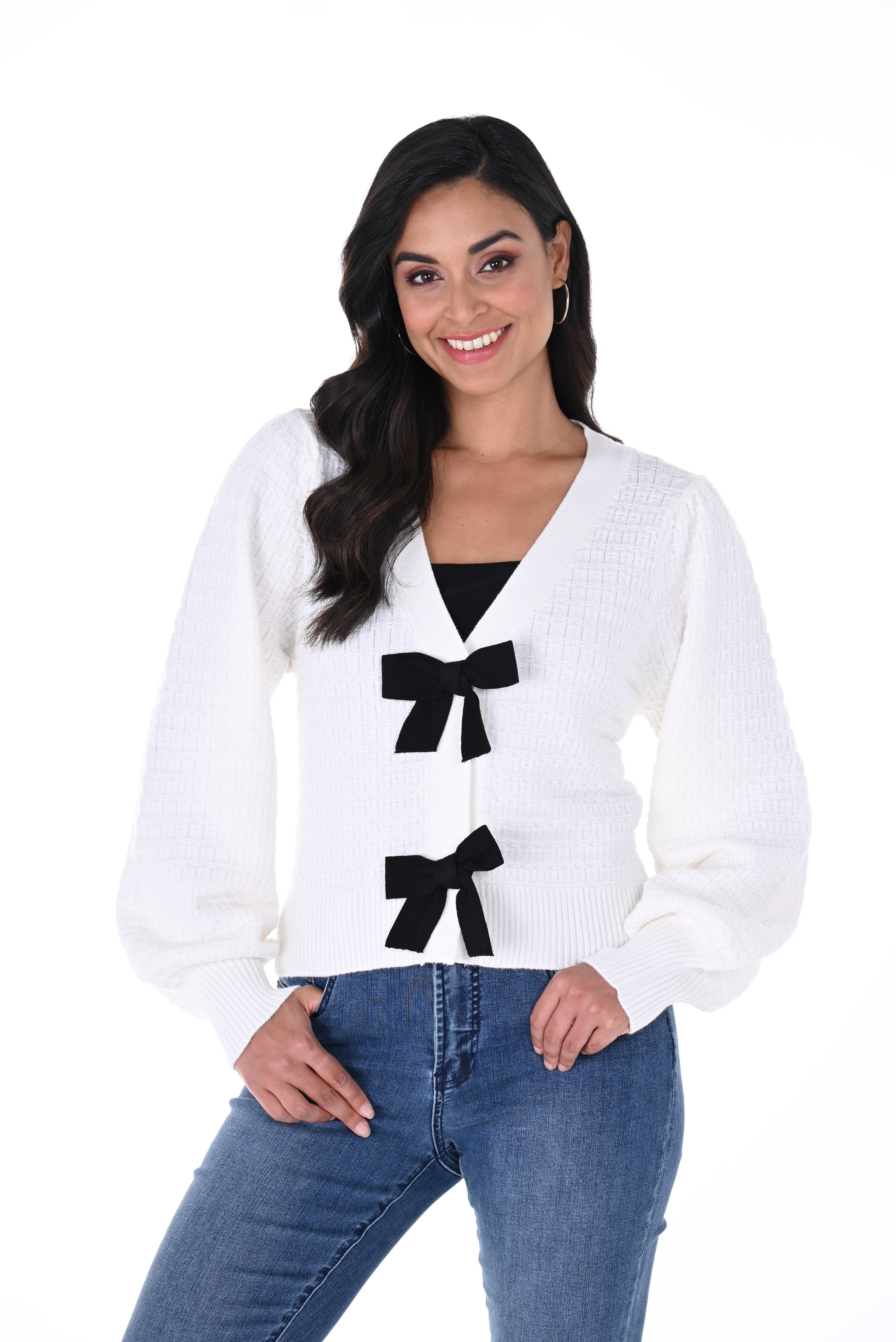 Woman wearing a white sweater with black bow designs on a white background