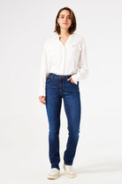 Woman wearing mid-rise straight-leg denim jeans with a fitted hip and clean five-pocket styling, front view.