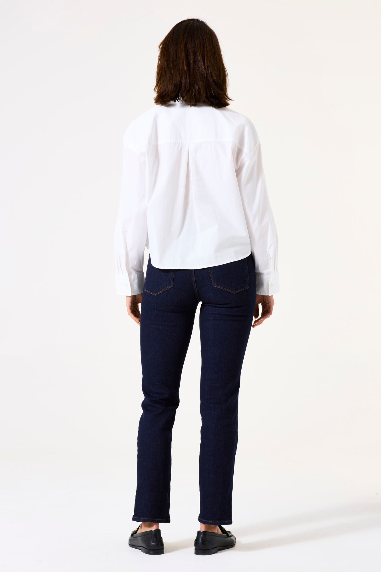 Back view of mid-rise straight-leg denim jeans featuring classic back pockets and a streamlined fit through the leg.