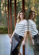 Woman standing in front of a glass door with a forest background