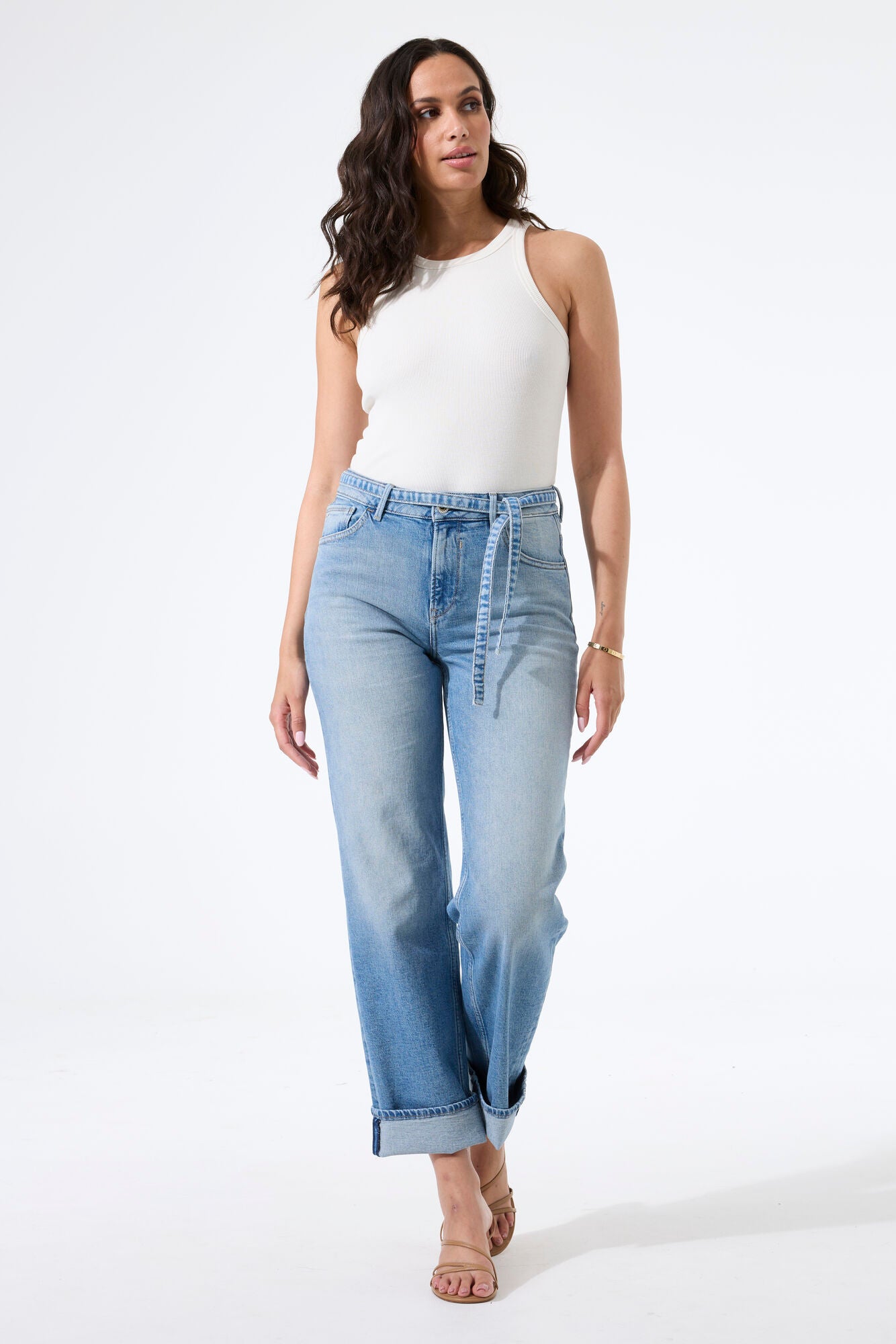 Model wearing high-rise straight-leg jeans with a fitted tank top and heeled sandals, shown from the front to highlight the fit and silhouette.