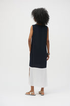 Back view of a model wearing the colourblock sleeveless dress with a navy top half and white bottom, showcasing side slits and a relaxed fit.