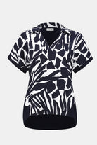 Navy and white abstract animal print short sleeve blouse with a collar and V-neckline.