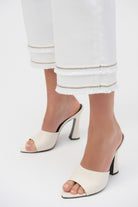 Detail of pant legs showing dual fringe bands and subtle metallic trim.