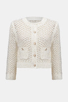 Flat lay of cream chenille open stitch cardigan with round gold buttons and front patch pockets.