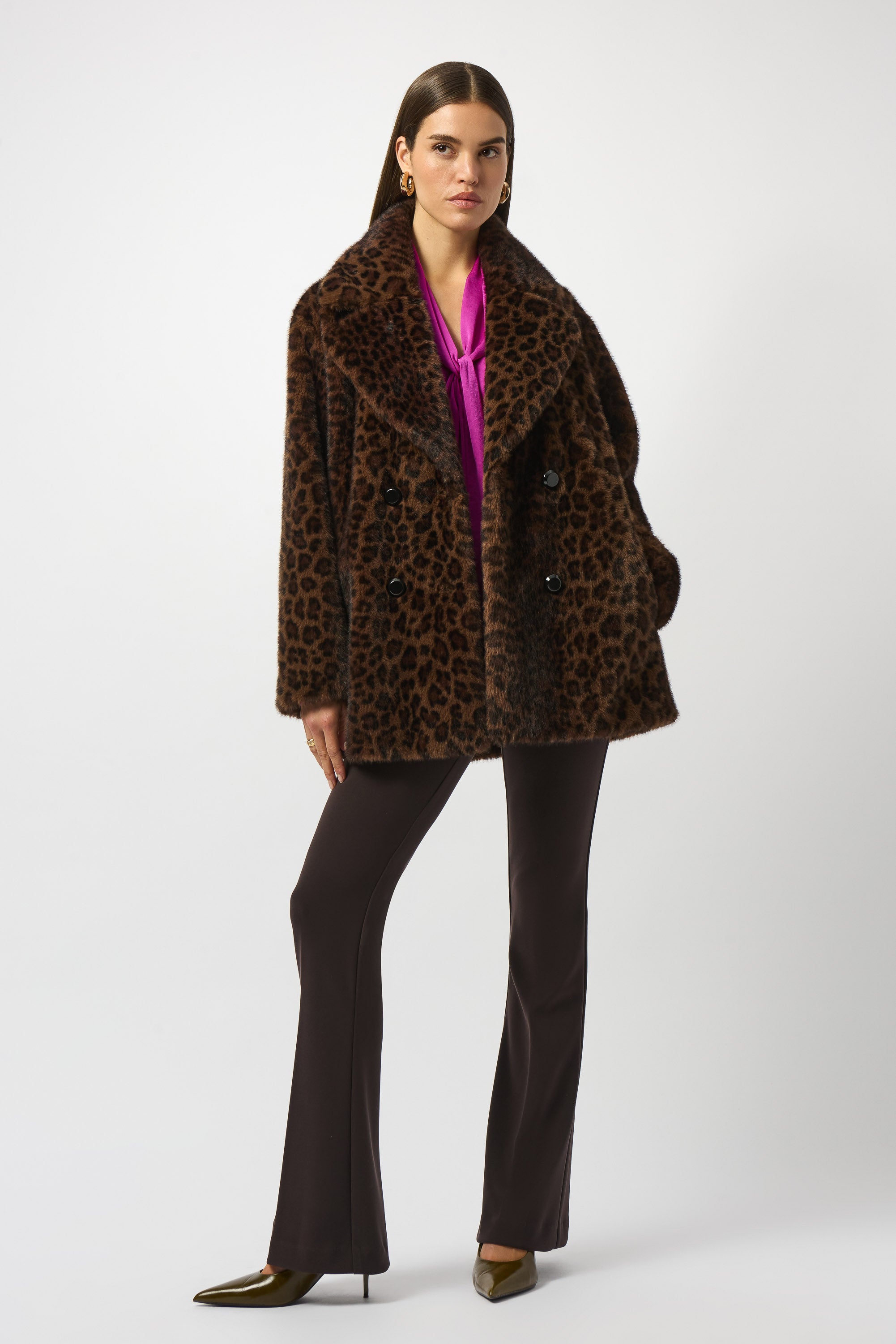 Woman wearing a leopard print coat and black pants on a white background