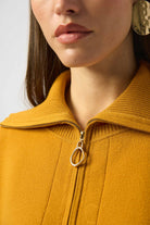 close-up image of a woman in mustard yellow zipper sweater