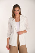 Model wearing a white pinstripe longline blazer with ruched three-quarter sleeves, shown from the side and back over wide-leg trousers.