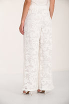 Back view of floral lace wide-leg pants featuring a relaxed fit and flowing silhouette.
