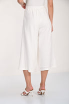 Front view of white wide-leg culotte pants featuring a cropped length, soft drape, and high-rise waistband.