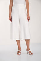 Back view of white wide-leg culotte pants with an elasticized waistband and flowy cropped silhouette.