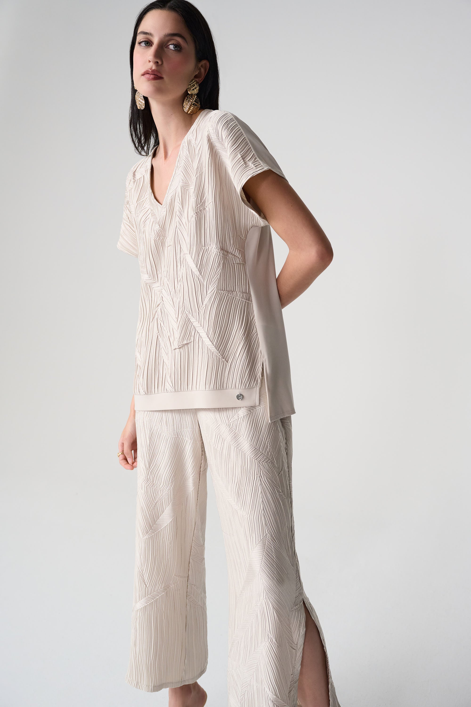 Pleated Satin V-Neck Top displayed on a model, showcasing its luxurious pleated satin fabric and stylish V-neckline.