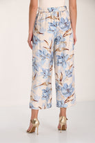 Women's blue floral wide-leg cropped pants with an elasticized back waistband, wide-leg silhouette, and cropped length. Back view.
