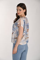 Women's floral print blouse featuring a relaxed silhouette, round neckline, and split sleeve detail. Shown from the back and side to highlight the easy fit, fluid drape, and lightweight woven fabric, paired with light wash jeans.