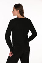 Back view of a women's knit cardigan with a relaxed silhouette, long sleeves, and a clean, minimalist design. Features a soft knit texture, ribbed hem and cuffs, and a classic round neckline.
