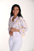 woman wearing a soft pink floral cropped jacket with button-front detail and white pants.