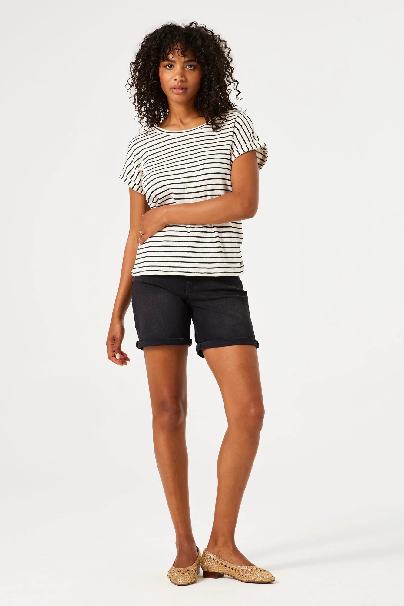 Woman wearing mid-length denim Bermuda shorts with rolled hems