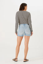 Back view of the model wearing the slim Bermuda shorts, highlighting the fit through the hips and thighs with a clean, streamlined silhouette.