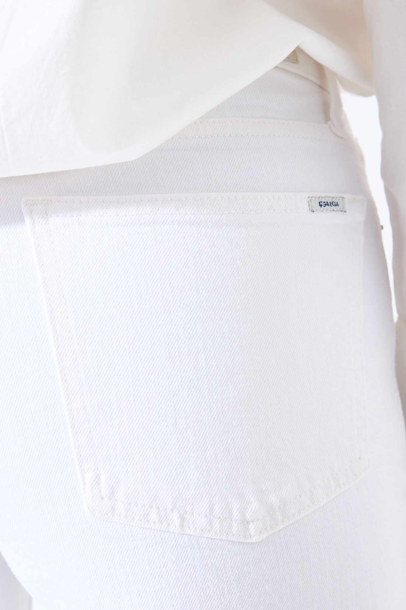 Women's white barrel-leg denim jeans. Zoomed into the pocket detail. 