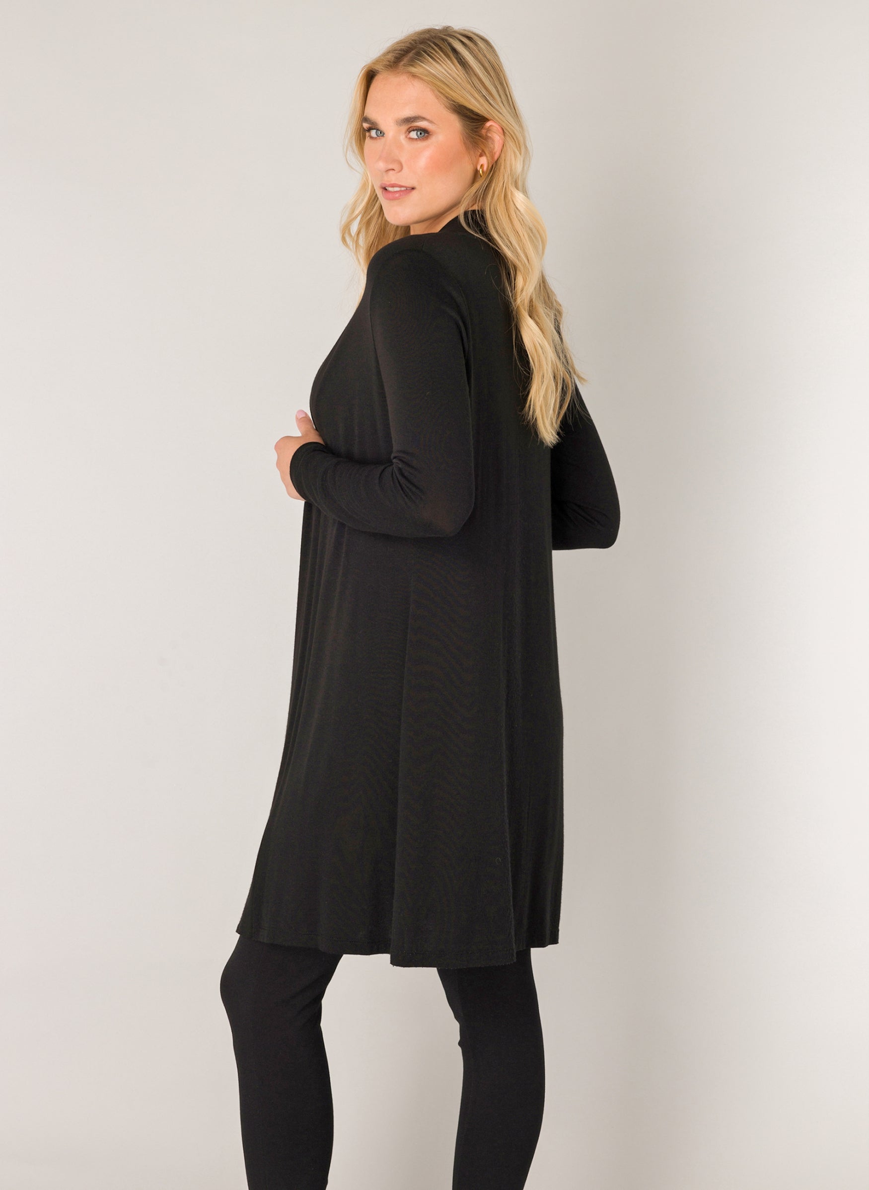 Women's black open-front cardigan shown from the back and side angle. The longline silhouette and lightweight fabric create an elegant drape, while the long sleeves and relaxed fit offer versatile everyday styling.