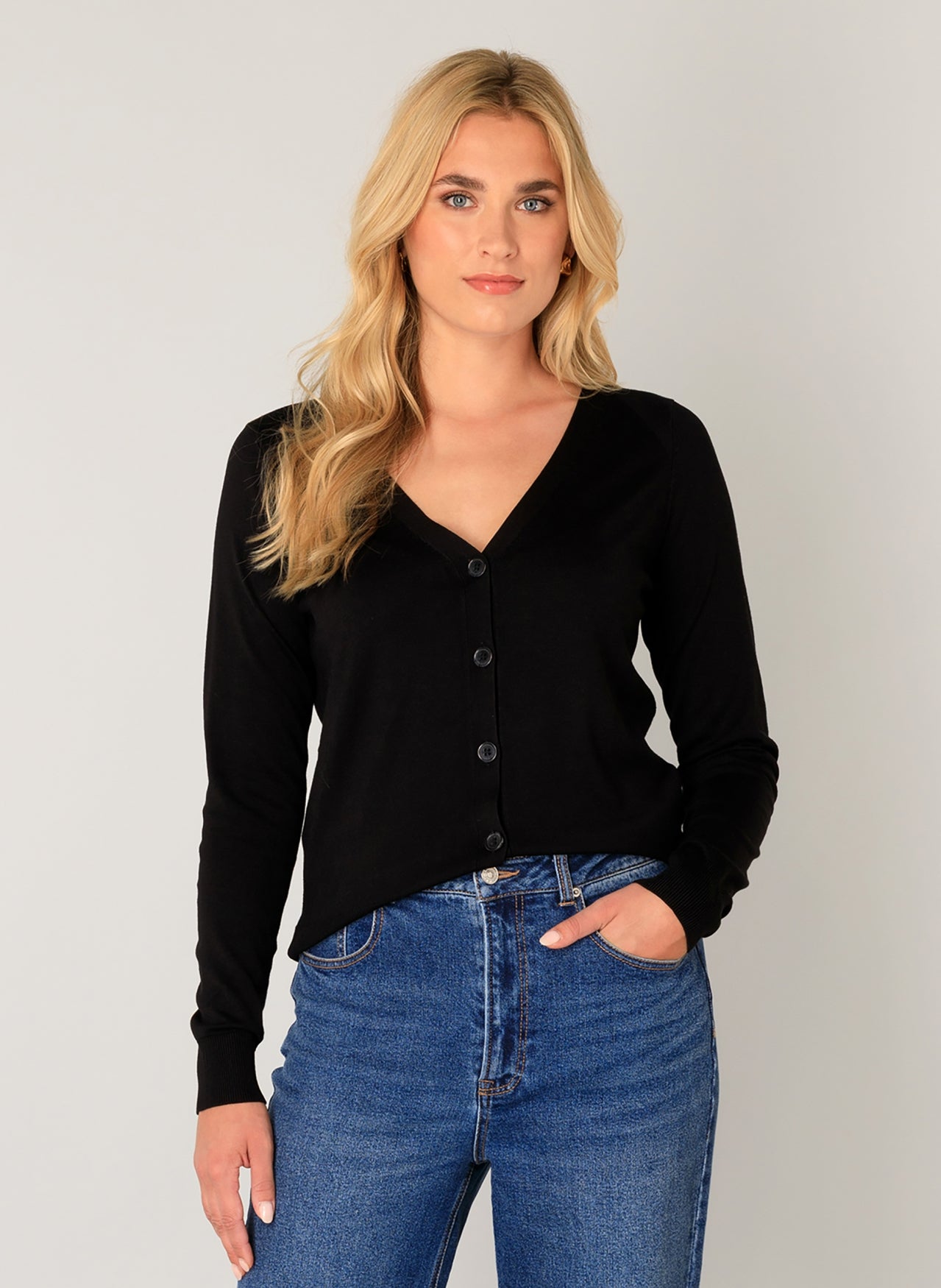 Women's black button-front cardigan with a V-neckline and long sleeves, shown from the front. Styled with wide-leg blue jeans and strappy sandals for a casual, polished look.