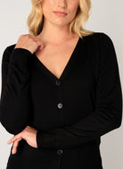 Close-up of a women's black fine-knit cardigan showcasing the V-neckline, button-front closure, and soft knit texture. Features ribbed cuffs and a refined, lightweight finish.