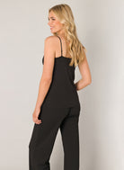 Back view of a black lace trim cami with adjustable spaghetti straps, shown paired with matching lounge pants.