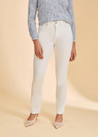 Front view of slim straight-leg pants in a light neutral tone, showing mid-rise fit, front pockets, and a clean silhouette with pointed low heels.