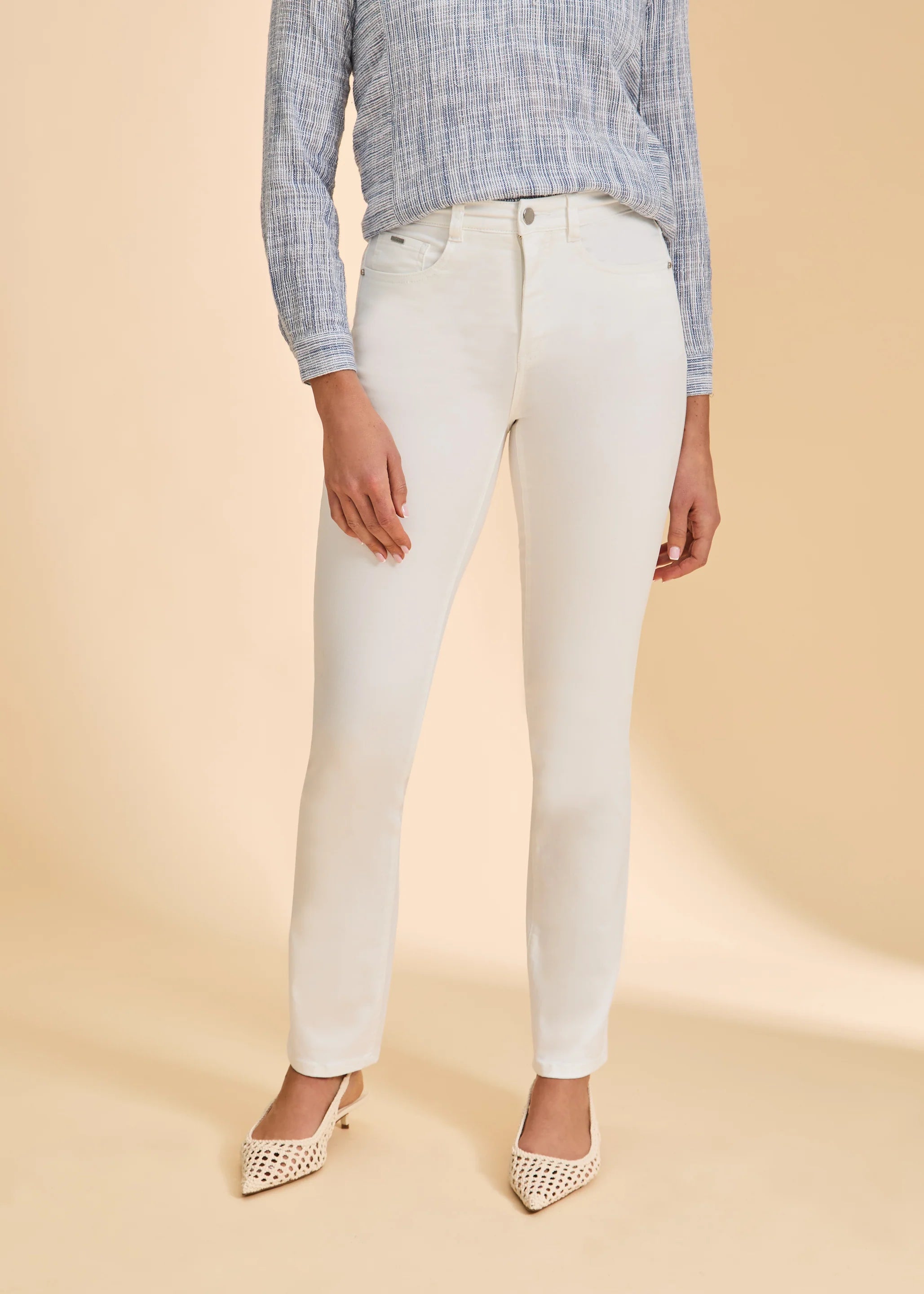 Front view of slim straight-leg pants in a light neutral tone, showing mid-rise fit, front pockets, and a clean silhouette with pointed low heels.