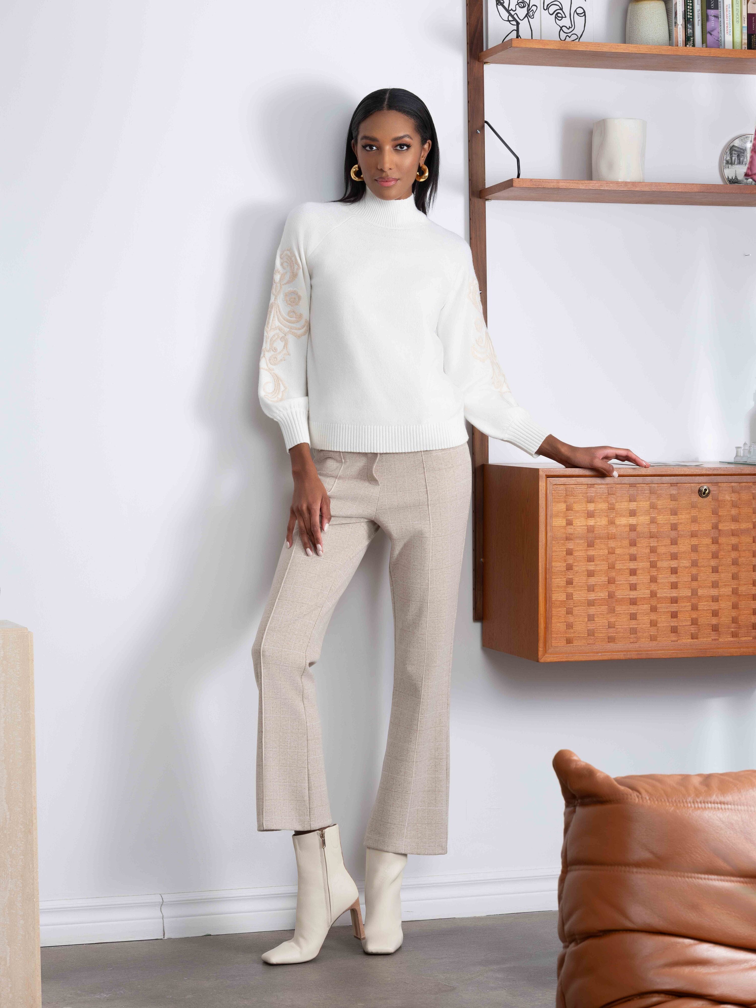 Woman wearing a white sweater with brown pants