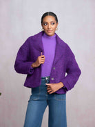 Woman wearing purple jacket and denim jeans