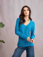 Woman wearing teal sweater and jeans