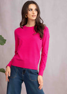 Woman wearing pink sweater and denim pants