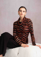 Woman wearing rust coloured striped sweater