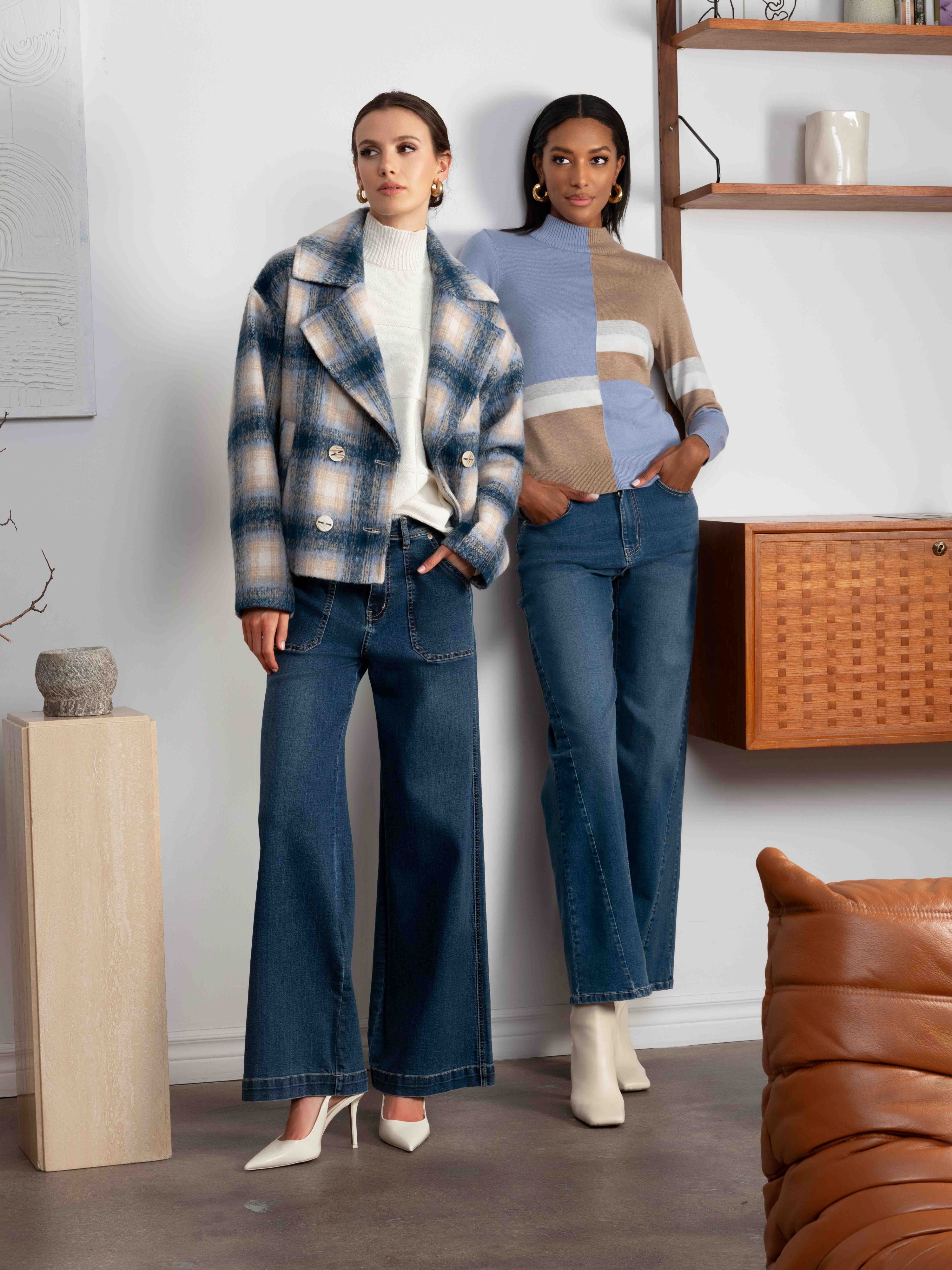 Two women standing side by side in a room with a modern interior.