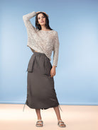 Model wearing a women’s open-stitch knit sweater with a relaxed fit, styled with a casual midi skirt and sandals.