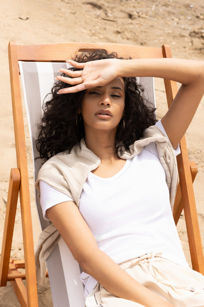 Women’s short-sleeve knit t-shirt styled casually, shown in a relaxed outdoor setting with a close-up view of the neckline, fit, and soft fabric texture.