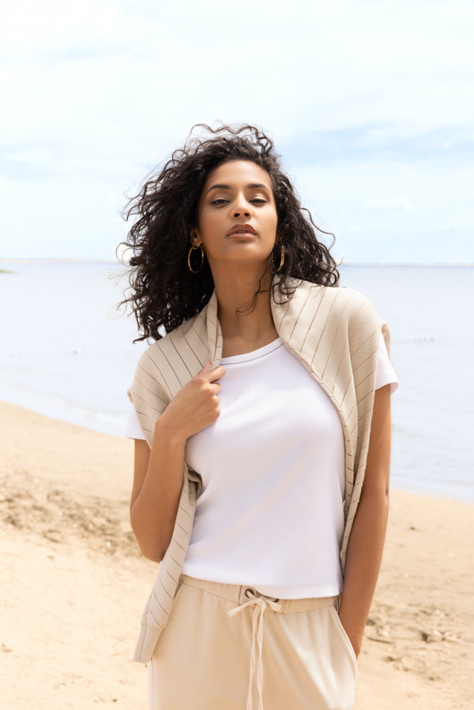 Women’s short-sleeve knit t-shirt styled casually, shown in a relaxed outdoor setting with a close-up view of the neckline, fit, and soft fabric texture.
