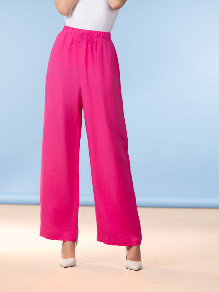 Wide-Leg Pant in bright pink featuring a relaxed wide-leg silhouette, elastic drawstring waistband, and lightweight linen-blend fabric, styled with neutral heels.