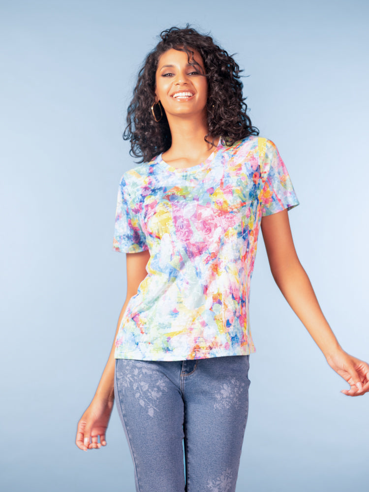 Woman wearing an abstract print short-sleeve crewneck T-shirt with a relaxed fit, paired with slim-fit jeans, shown against a neutral studio background.