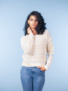 Women’s cream open-knit sweater with subtle multicolour speckles, long sleeves and crew neckline, styled with fitted blue jeans.