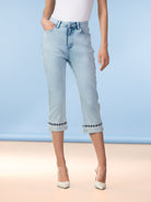 Women’s light wash cropped denim jeans with a slim straight-leg fit, classic five-pocket styling, and embroidered detail along the cuffed hem, shown paired with pointed-toe heels.