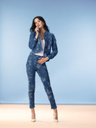 Model wearing a blue floral print denim jacket with matching high-rise skinny jeans, white top, and pointed heels, front full-length view.