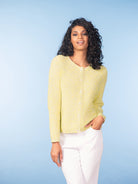 Woman modelling a long-sleeve knit cardigan with a crew neckline and button-front closure, styled with tailored trousers against a studio background.