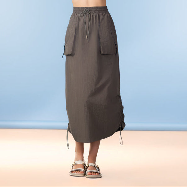 Woman wearing a textured top and brown skirt against a blue background