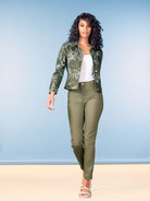 Model wearing reversible slim-fit pants in olive green paired with a printed utility jacket and white tank top, styled with flat sandals.