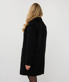 Black long bouclé cardigan coat shown from the back on a model, featuring a relaxed fit and collar.