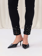 Detail shot of black denim ankle embellishment