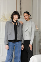 2 women standing in grey outfits