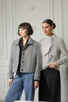 2 women standing in grey outfits